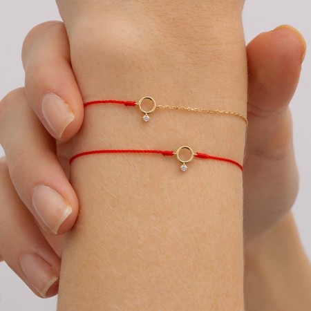 Гривна с червен конец и златен елемент карма